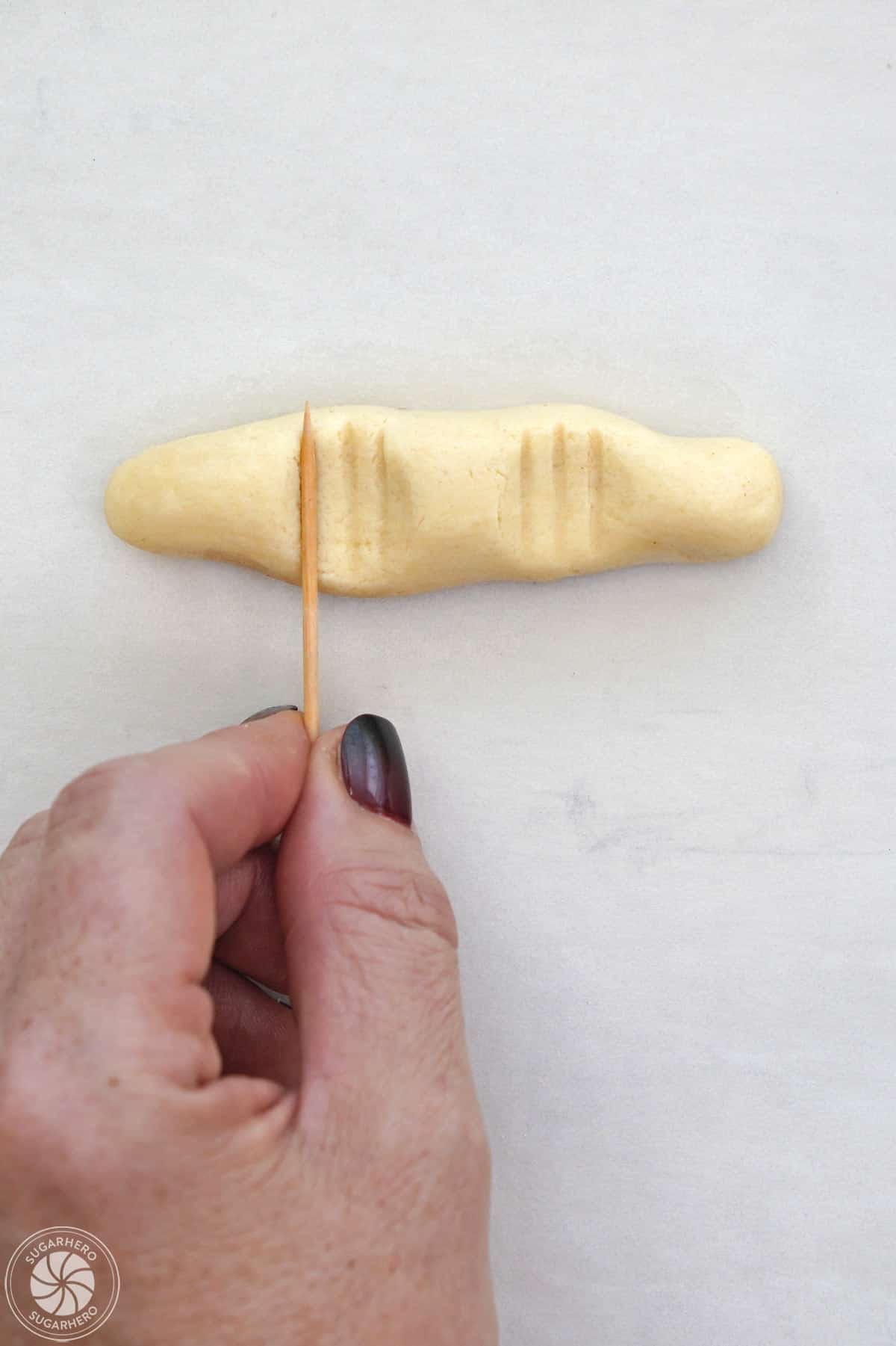 Adding lines to the top of a witch finger cookie.
