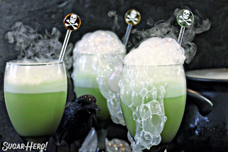 Close-up of three goblets with green punch and smoke bubbling out the top