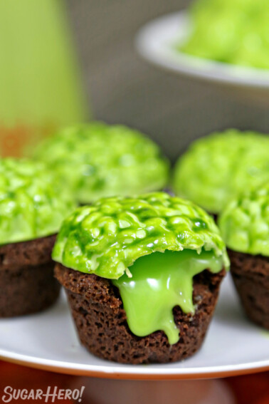 Close up of oozing Zombie Brain Brownie Bite on a plate with several more brownie bites in the background.